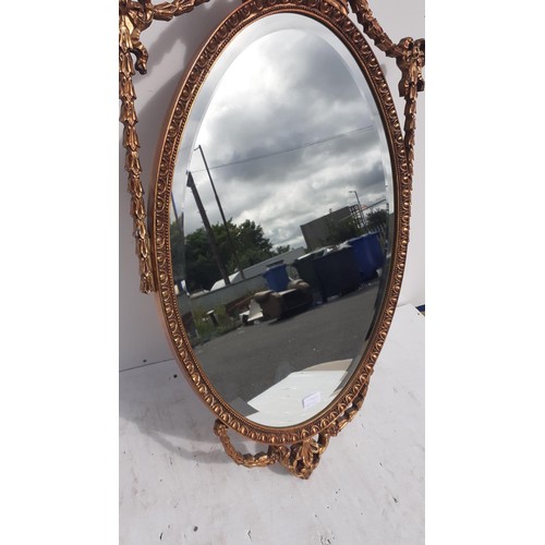 702 - AN ORNATE GILT BEVELL EDGE MIRROR