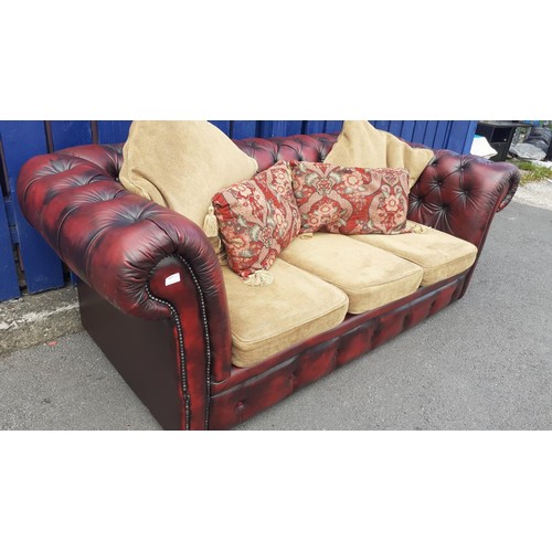 703 - A DEEP BUTTONED OXBLOOD CHESTERFIELD SETTEE