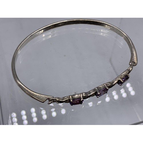 242 - A SILVER AND AMETYST SET BANGLE