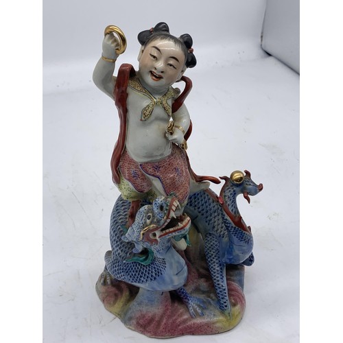 333 - A CHINESE MAN ON DRAGON HOLDING GILT BAND PORCELAIN FIGURE 8