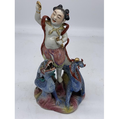 333 - A CHINESE MAN ON DRAGON HOLDING GILT BAND PORCELAIN FIGURE 8