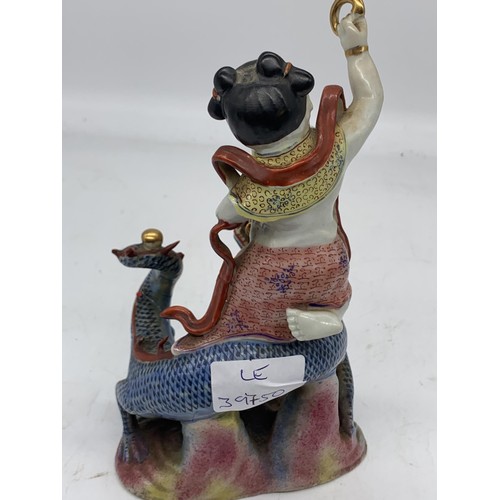 333 - A CHINESE MAN ON DRAGON HOLDING GILT BAND PORCELAIN FIGURE 8