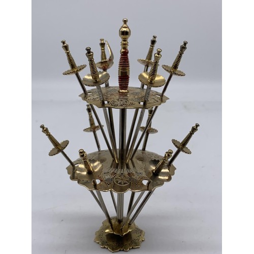 352 - AN INDIAN BRASS SWORD COCKTAIL SET