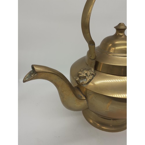 494 - A HEAVY BRASS KETTLE WITH LION HEAD HANDLES