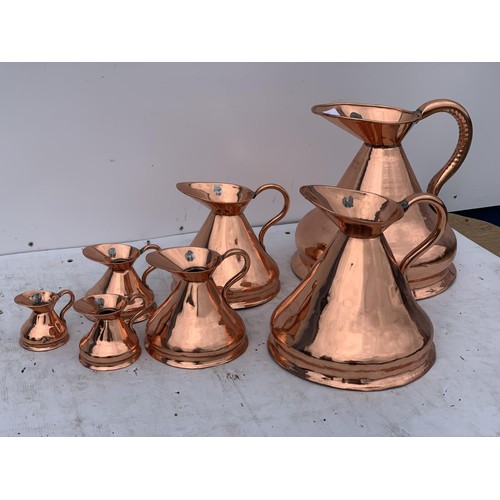 501 - 7 GRADUATED COPPER JUGS