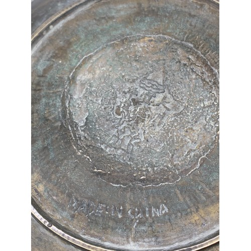 602 - A CHINESE BRASS PLATE DEPICTING  DRAGONS WITH MARKINGS TO BASE 11in Dia