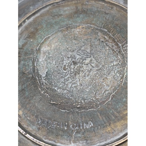 602 - A CHINESE BRASS PLATE DEPICTING  DRAGONS WITH MARKINGS TO BASE 11in Dia