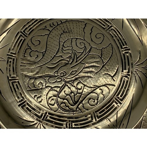 602 - A CHINESE BRASS PLATE DEPICTING  DRAGONS WITH MARKINGS TO BASE 11in Dia