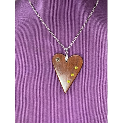 231 - A WOODEN HEART SET WITH STONE ON A SILVER CHAIN