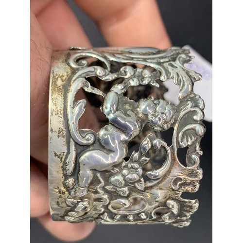 204 - AN ORNATE SILVER CUP HOLDER EMBOSSED WITH CHERUBS 16.9grms