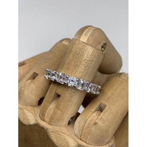 257 - A HEAVY SILVER DESIGNER STYLE GEM SET ETERNITY RING