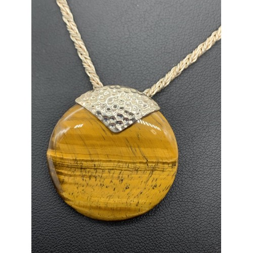 637 - A BEAUTIFUL SILVER MOUNTED TIGERS EYE PENDANT ON A SILVER CHAIN