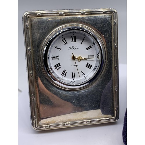 653 - A SILVER MOUNTED MINITURE CLOCK (WORKING ORDER AND IN BOX)