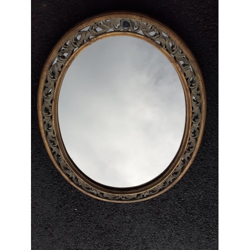 886 - AN ORNATE OVAL GILT MIRROR 22X28