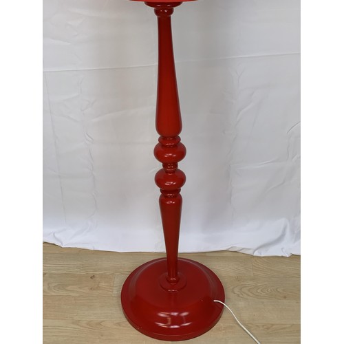 142 - A DESIGNER STANDARD LAMP IN RED COMPLETE WITH A RED SHADE