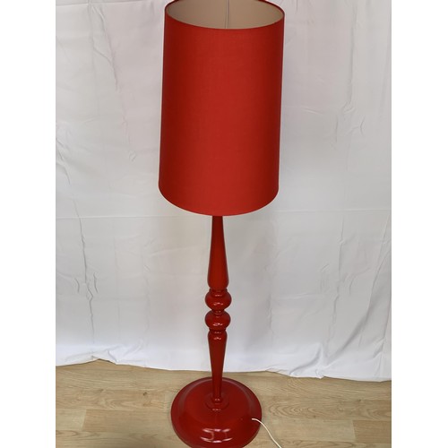 142 - A DESIGNER STANDARD LAMP IN RED COMPLETE WITH A RED SHADE