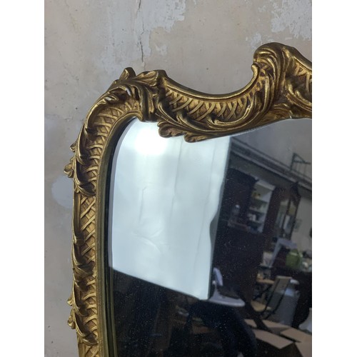 210A - A BEAUTIFUL SHAPED ORNATELY GILT FRAMED METAL MIRROR 41X26.5