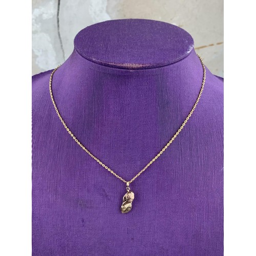 600 - A 9ct GOLD DOUBLE LEAF PENDANT ON A ROLLED GOLD CHAIN