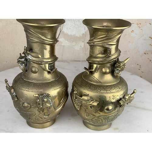 652 - A PAIR OF ORIENTAL HEAVY BRASS VASE EMBOSSED WITH DRAGONS 9.25