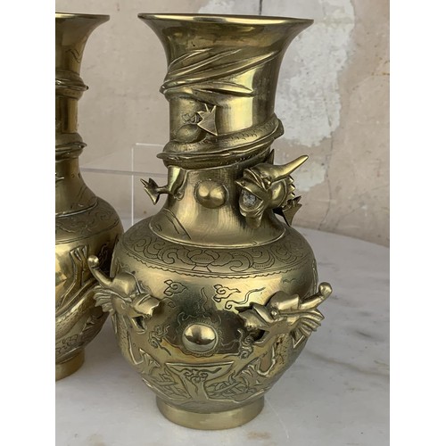 652 - A PAIR OF ORIENTAL HEAVY BRASS VASE EMBOSSED WITH DRAGONS 9.25