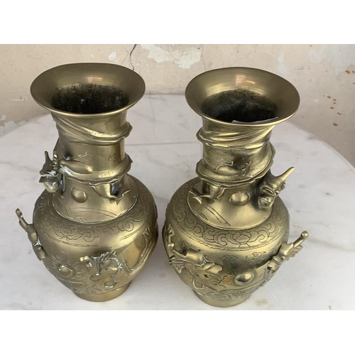 652 - A PAIR OF ORIENTAL HEAVY BRASS VASE EMBOSSED WITH DRAGONS 9.25