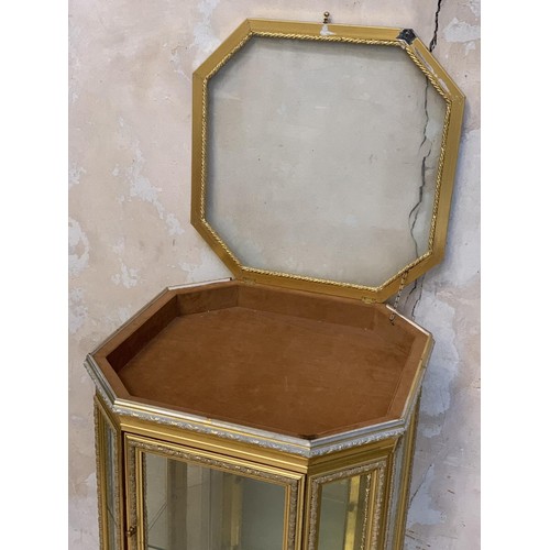 662 - A SHAPED GILT 3 TIER DISPLAY CABINET WITH A LIFT LID DISPLAY TOP 23 x 44