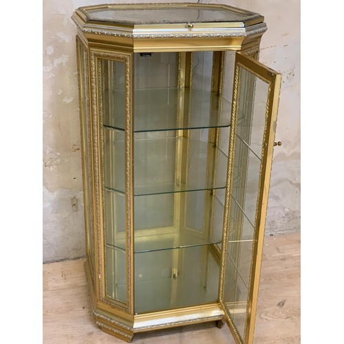 662 - A SHAPED GILT 3 TIER DISPLAY CABINET WITH A LIFT LID DISPLAY TOP 23 x 44