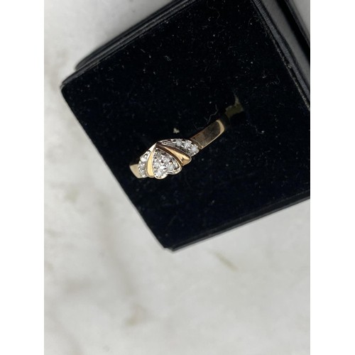 569 - A 9ct GOLD RING SET WITH DIAMONDS FORMING A HEART SIZE N