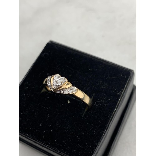 569 - A 9ct GOLD RING SET WITH DIAMONDS FORMING A HEART SIZE N