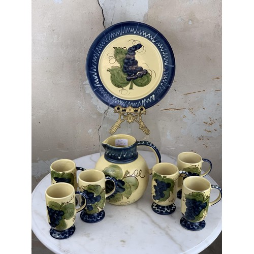 100 - A COLLECTION OF POTTERY DEPICTING GRAPES TO INCLUDE A JUG, PLATE & 6 MUGS