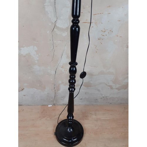 9 - AN EBONY STANDARD LAMP WITH A SHADE