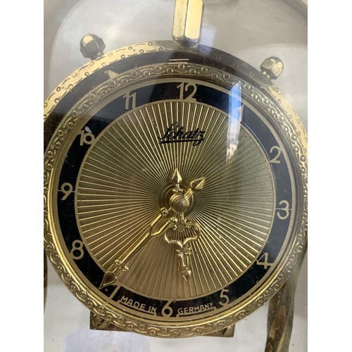 388 - A BRASS GERMAN WORKS ANNIVERSARY CLOCK UNDER GLASS DOME