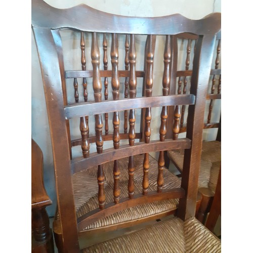 423 - A SET OF 8 OAK SPINDLE BACK CHAIRS WITH TURNED STRETCHES AND RUSH SEATS (2 CARVERS AND 6 CHAIRS)