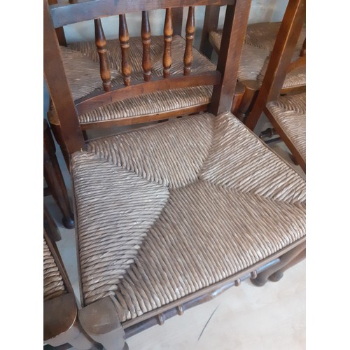 423 - A SET OF 8 OAK SPINDLE BACK CHAIRS WITH TURNED STRETCHES AND RUSH SEATS (2 CARVERS AND 6 CHAIRS)