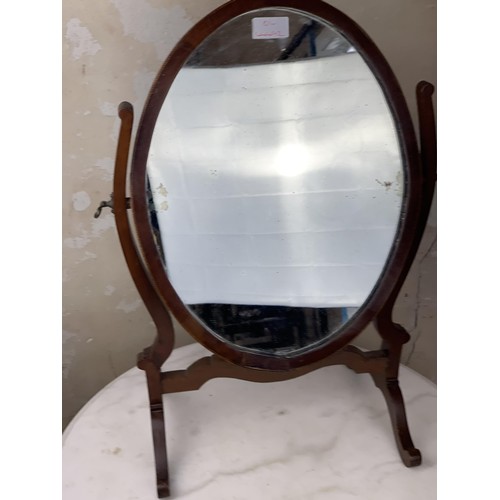 517 - AN OVAL INLAID DRESSING TABLE MIRROR IN A SHAPED FRAME