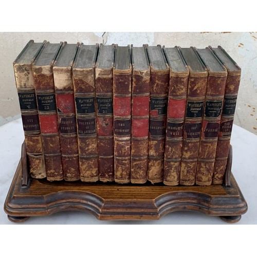 523 - AN ANTIQUE MAHOGANY BOOK STAND HOLDER AND BOOKS