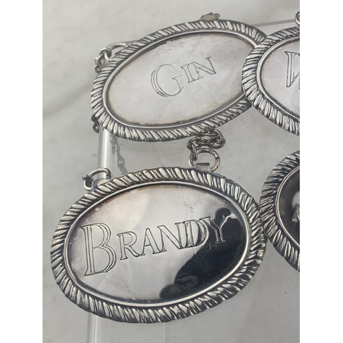 110A - A SET OF 4 SILVER PLATED WHISKEY, GIN, SHERRY AND BRANDY DECANTER LABELS