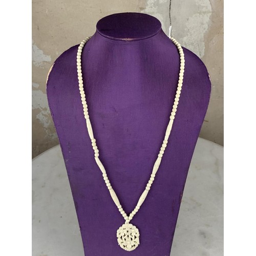 236 - ORNATE CARVED NECKLACE WITH A FLORAL DESIGN PENDANT