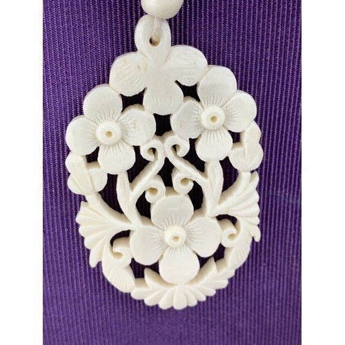 236 - ORNATE CARVED NECKLACE WITH A FLORAL DESIGN PENDANT