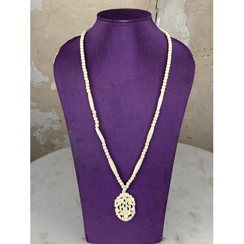 236 - ORNATE CARVED NECKLACE WITH A FLORAL DESIGN PENDANT