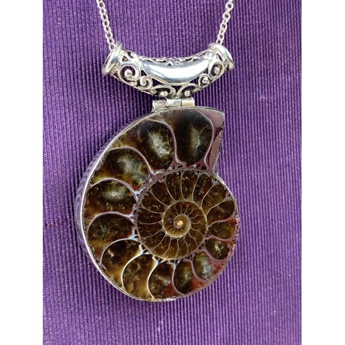 435 - LARGE FOSSIL PENDANT SET IN AN ORNAMENT SILVER MOUNT OF A SILVER CHAIN