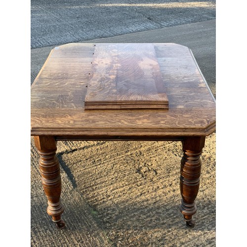 430 - AN ANTIQUE OAK WIND OUT TABLE COMPLETE WITH AN EXTRA LEAF & HANDLE