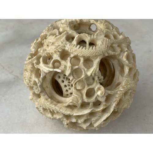 578 - AN ORIENTAL PUZZLE BALL MADE FROM BONE DEPICTING DARGONS