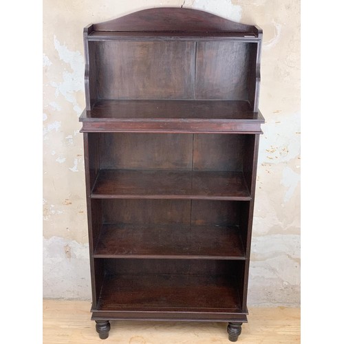 697 - A SOLID MAHOGANY OPENING SHELVING ON TURNED FOOT MEASURES 27 x 11 x 55