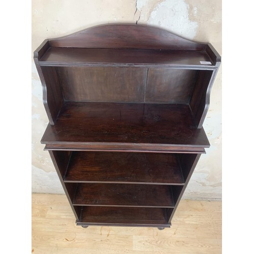 697 - A SOLID MAHOGANY OPENING SHELVING ON TURNED FOOT MEASURES 27 x 11 x 55