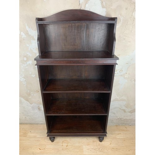 697 - A SOLID MAHOGANY OPENING SHELVING ON TURNED FOOT MEASURES 27 x 11 x 55