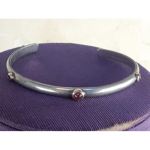 586A - A SILVER CUFF BANGLE SET WITH RUBY, SAPPHIRE AND GARNET