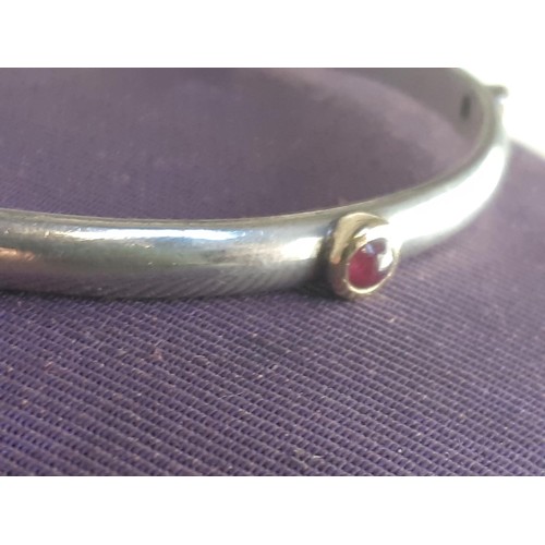 586A - A SILVER CUFF BANGLE SET WITH RUBY, SAPPHIRE AND GARNET