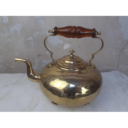 54 - A BRASS KETTLE WITH AN AMBER HANDLE