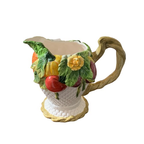 104 - A HAND PAINTED JUG ADORNED WITH FRUIT